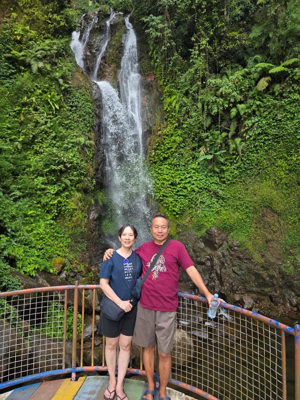 Papi dan Mami berfoto di depan air terjun